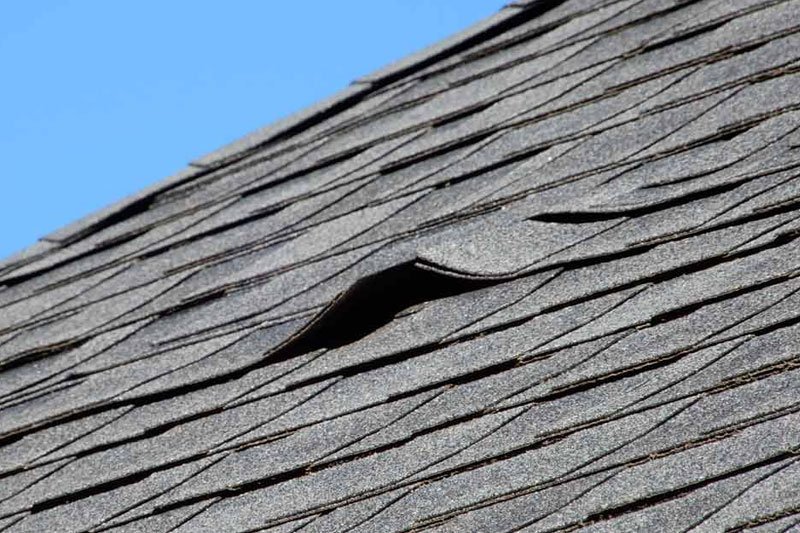 Shingles sticking up on a poorly installed roof.